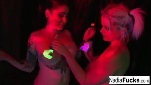 Black-light Babes Nadia and Ophelia Suck off a Colorful Cock